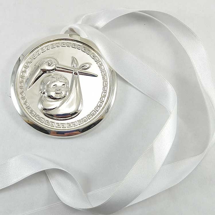Medalla para cuna de bebé en plata bilaminada con cigüeña y niño